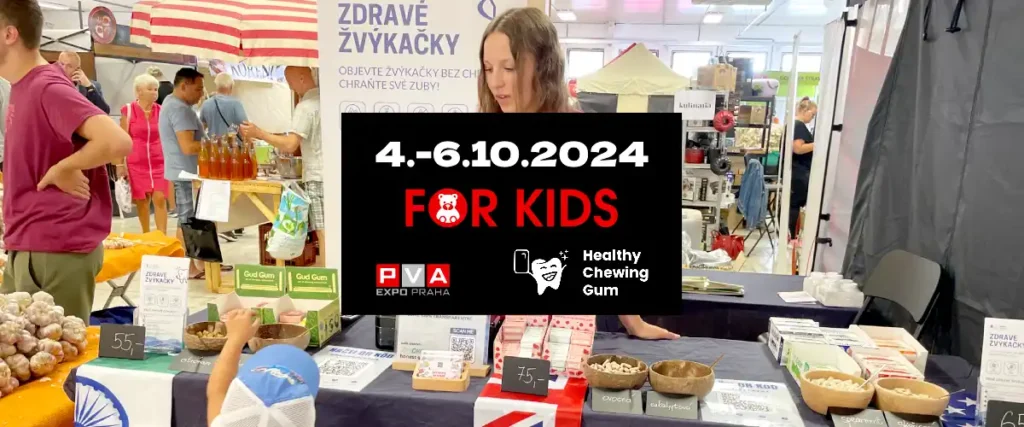 Fotografie v pozadí z výstavy - v popředí černý obdelník s informací o výstavě FOR KIDS 2024 na výstavišti PVA EXPO Praha - pozvánka pro všechny, kdo mají zájem o zdravé žvýkačky bez škodlivé chemie, bez aspartamu, bez cukru, bez syntetických konzervantů, barviv a sladidel | Autor: Jiří Samuel | Pro web: zdravezvykacky.cz a healthychewinggum.com